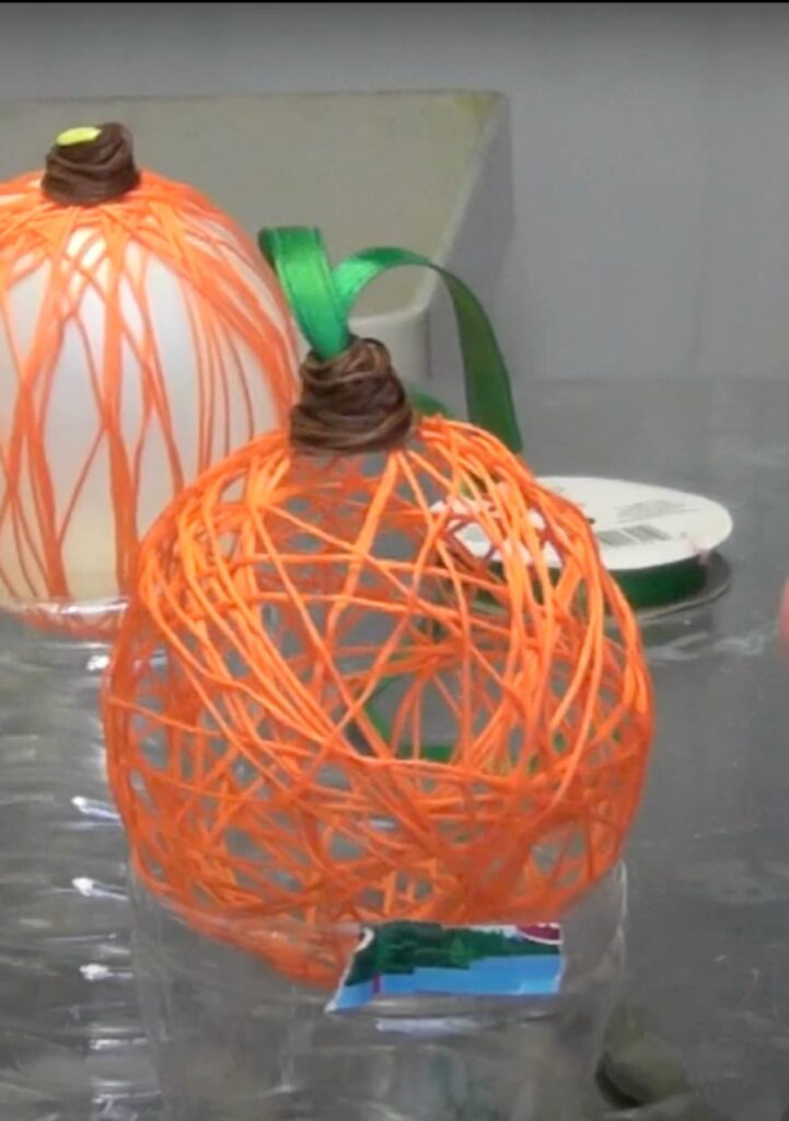 String pumpkin craft drying on water bottle