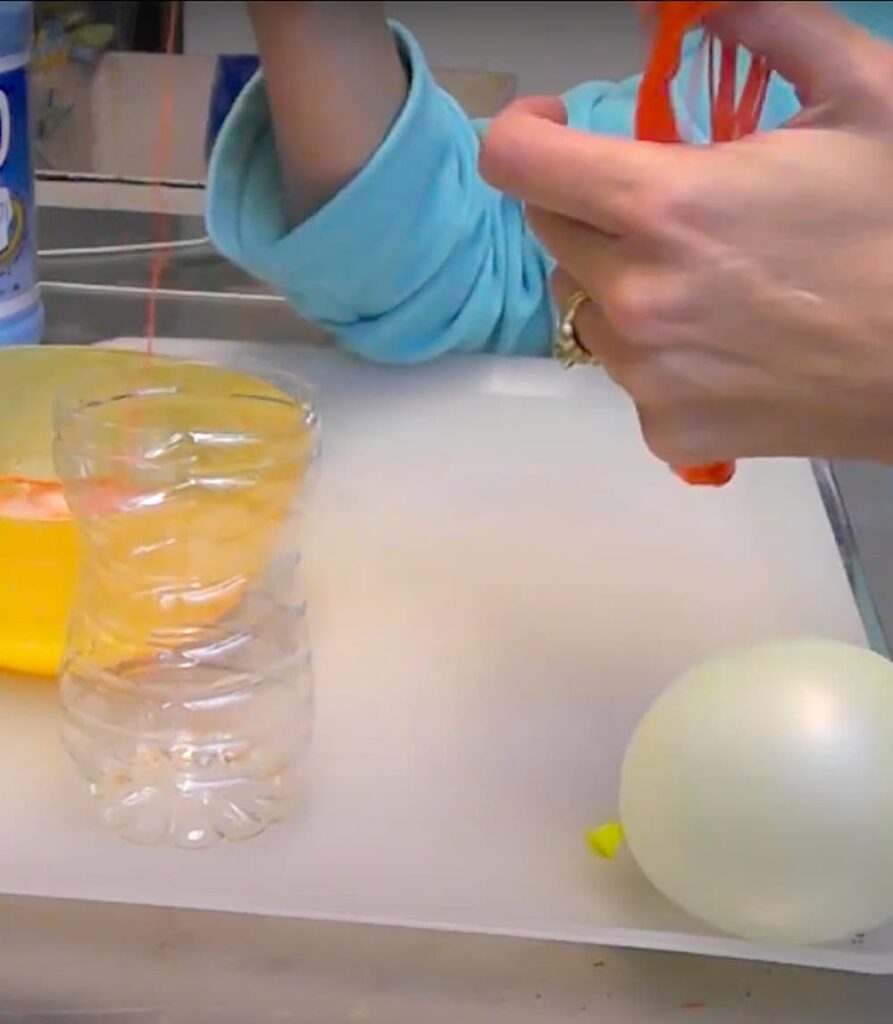 unwinding orange embroidery floss into starch bowl