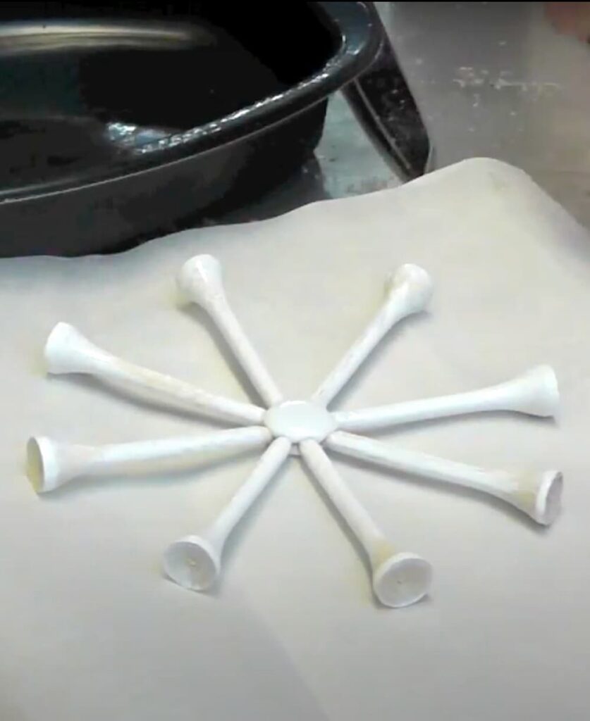 how to make a snowflake with golf tees arranges in the shape of a snowflake and painted white