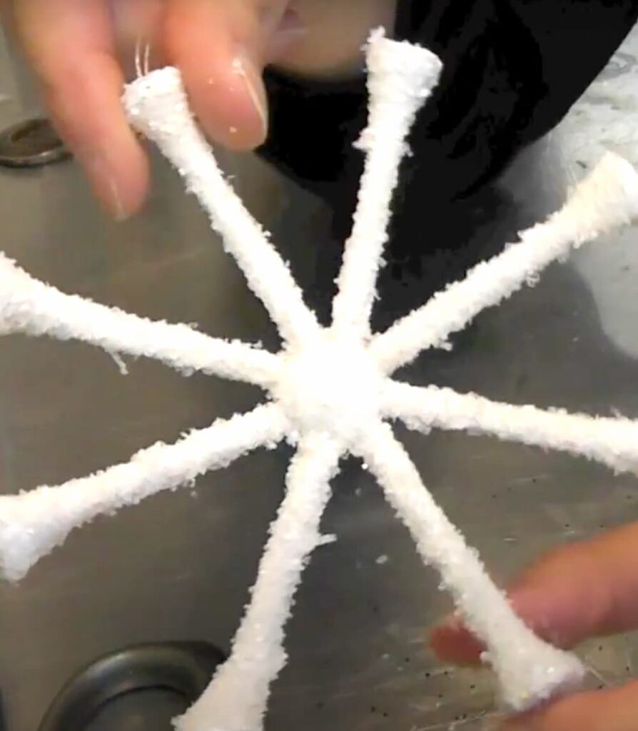 Finished glittered snowflake ornament made out of golf tees