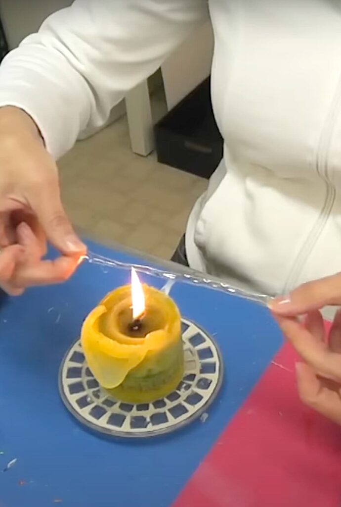 Melting a plastic strip over a candle flame for the dandelion wish flower
