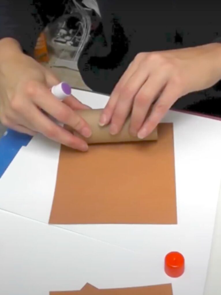 Rolling toilet paper roll into brown construction paper to make the toilet paper roll turkey crafts body