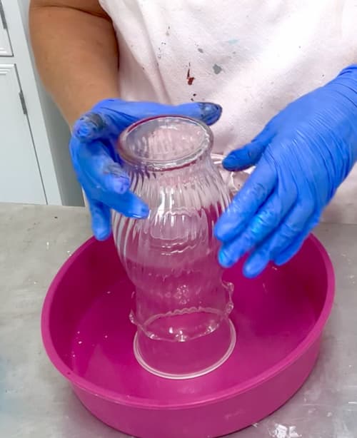 Use a cup and a mold to raise up the vase to prep it for pouring
