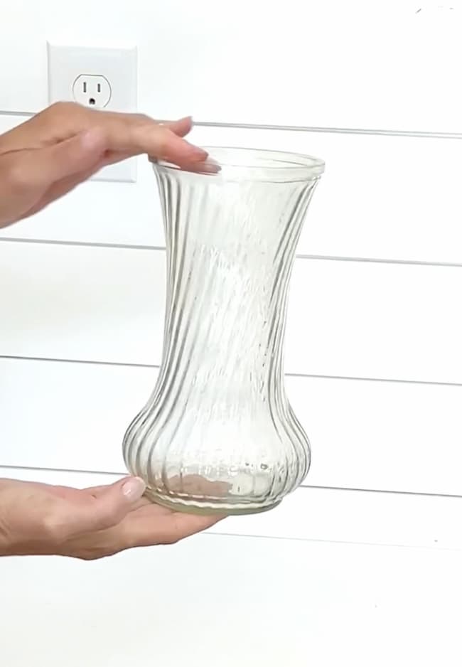 Holding clear vase between two hands
