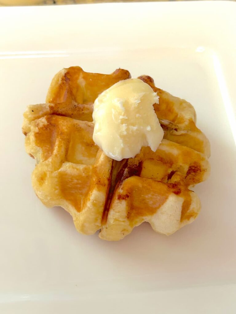 Cinnamon roll waffle cooked in a waffle iron