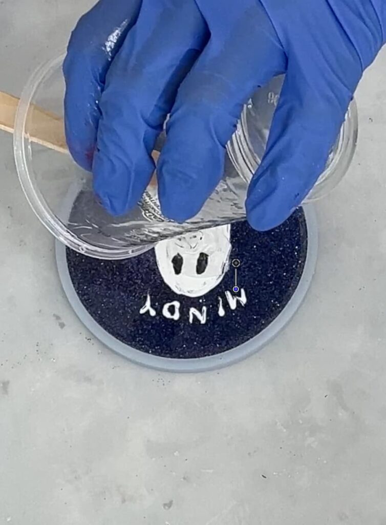 Pouring the top layer or resin over the painted ghost coaster