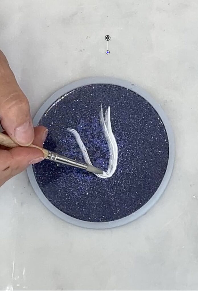 Showing how to paint a ghost on a resin coaster