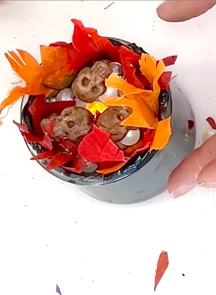 Top view of witches cauldron with flames and skulls