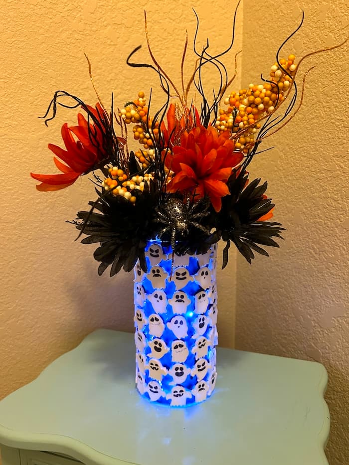 Finished Spooky ghost halloween decoration using a dollar tree vase with flowers and all lit up