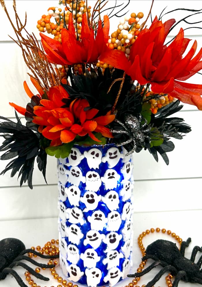 Finished spooky ghost halloween decoration with fall flowers and spiders