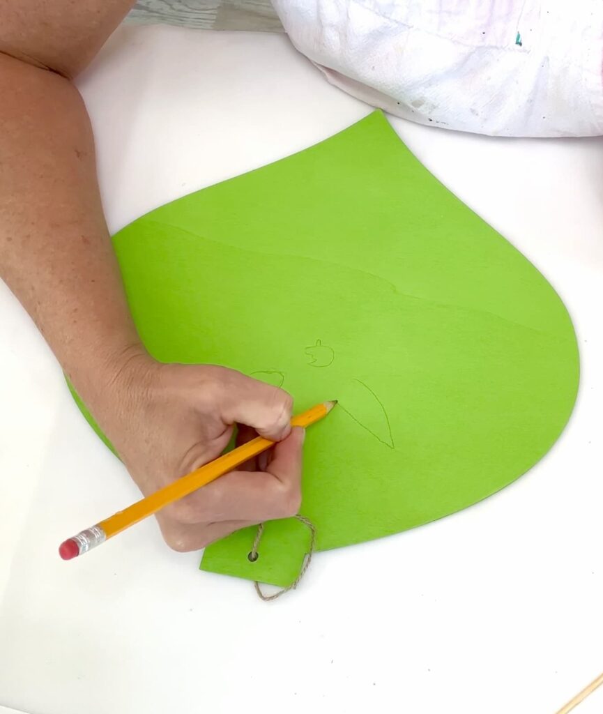 Sketching the Grinch face on a green ornament