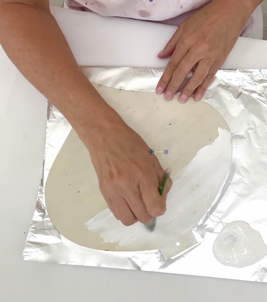 Painting the dollar tree ornament white for the snowman craft