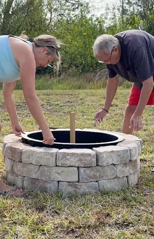 figuring out how to build a firepit and placing the metal ring in place