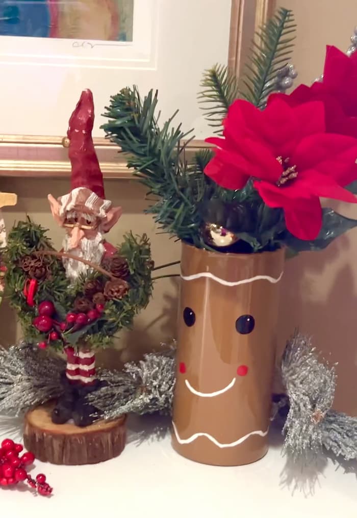 Finished gingerbread man vase after showing how to make a gingerbread man dollar tree christmas craft with santa elf standing next to it