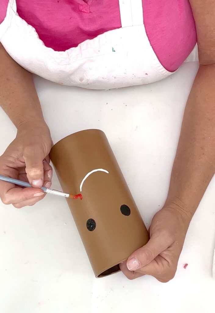 how to make a gingerbread man face by painting the features including rosy cheeks